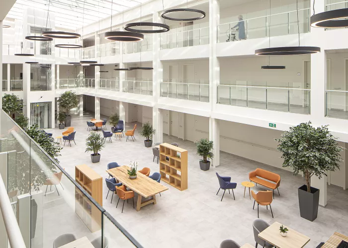 interieur WZC Avondzon met zwarte, grijze en cognac zorgstoelen in atrium
